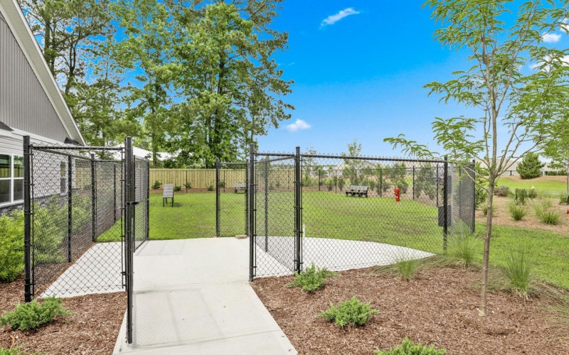 a fenced in yard with a gate and trees