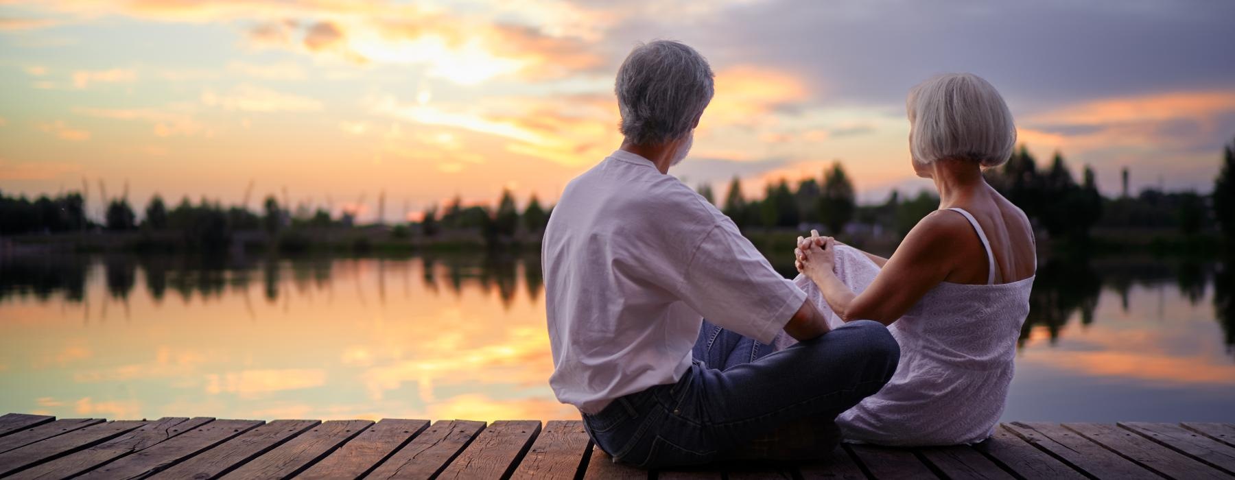 Two residents sitting outside near our 55 and older rental homes in Dallas, NC, featuring a sunset in the background.